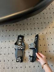 ALAIA FOLDED FLAT MULES WITH SPHERES ON BLACK CALFSKIN