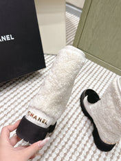 CHANEL 25S ANKLE BOOTS IN WHITE SHEARLING LAMBSKIN AND BLACK PATENT CALFSKIN