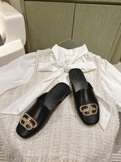 FLAT MULES IN BLACK SMOOTH CALFSKIN GOLD BUCKLE