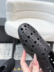ALAIA 26S FLAT SLIP-ONS IN BLACK CALFSKIN WITH OPENWORK PATTERN