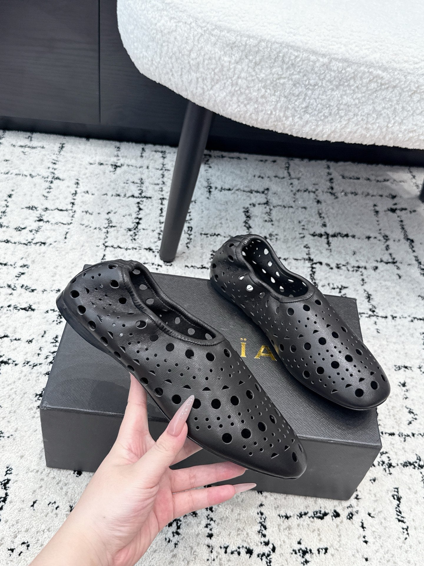ALAIA 26S FLAT SLIP-ONS IN BLACK CALFSKIN WITH OPENWORK PATTERN