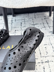 ALAIA 26S FLAT SLIP-ONS IN BLACK CALFSKIN WITH OPENWORK PATTERN