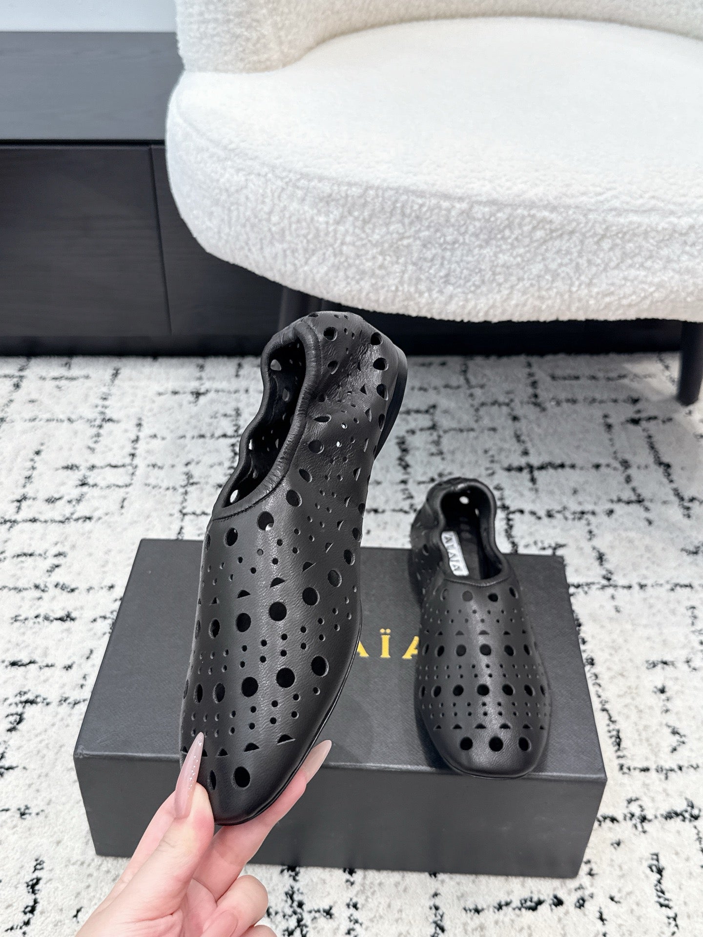 ALAIA 26S FLAT SLIP-ONS IN BLACK CALFSKIN WITH OPENWORK PATTERN