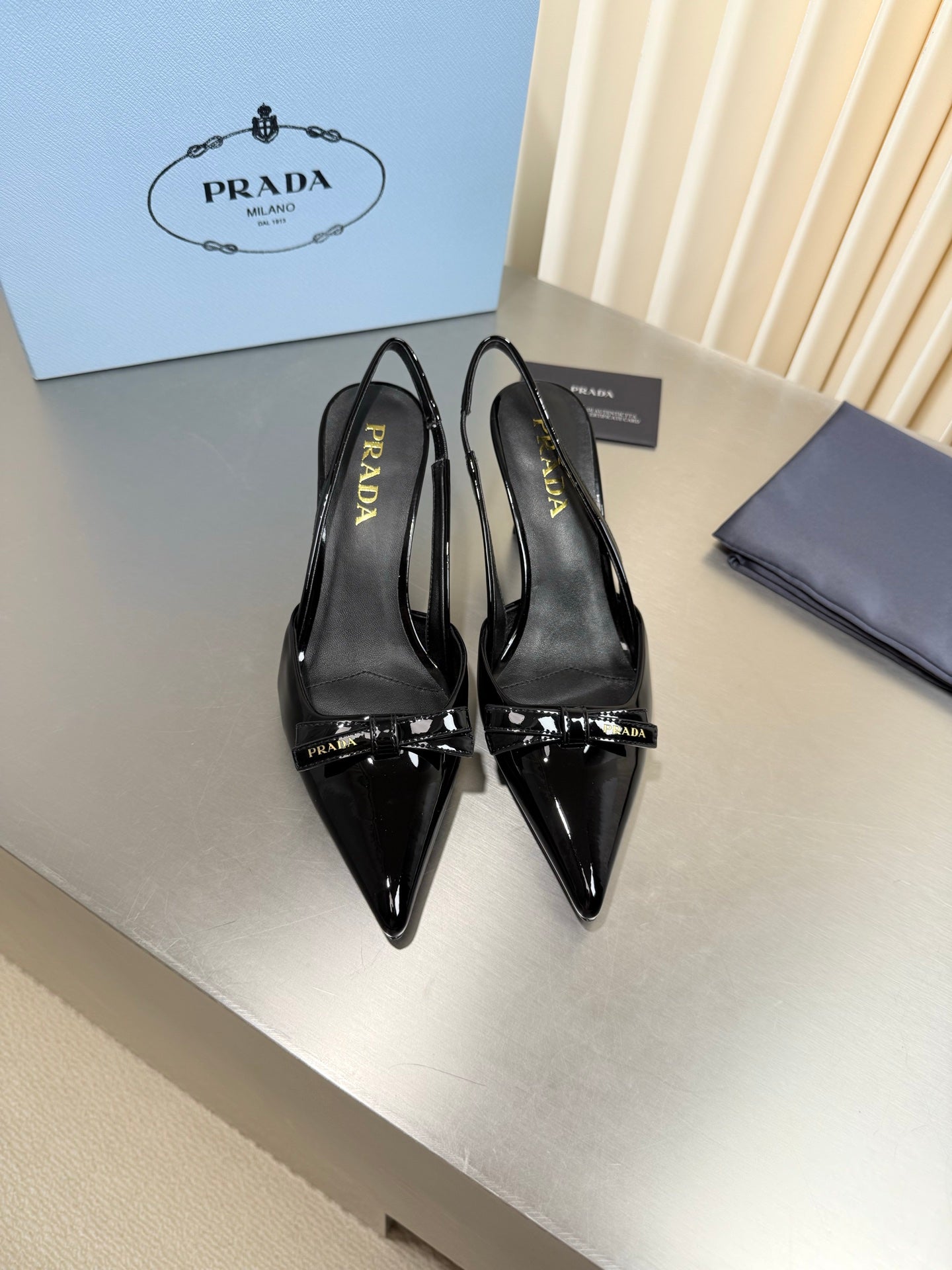 PRADA 26S POINTED-TOE SLINGBACK PUMPS IN BLACK PATENT CALFSKIN WITH BOW