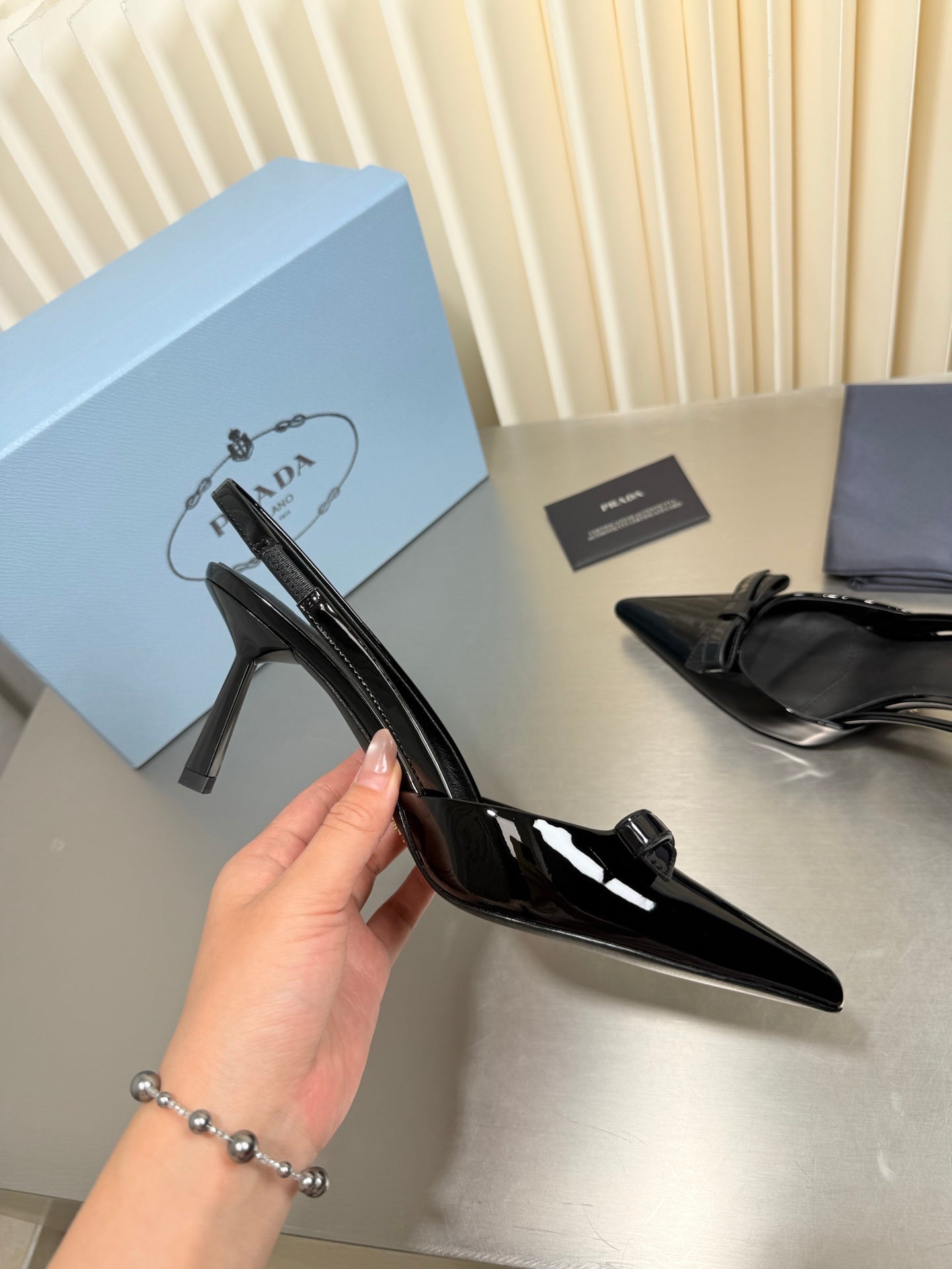 PRADA 26S POINTED-TOE SLINGBACK PUMPS IN BLACK PATENT CALFSKIN WITH BOW