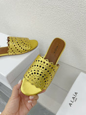 ALAIA VIENNE FLAT MULES IN GOLDEN LAMBSKIN
