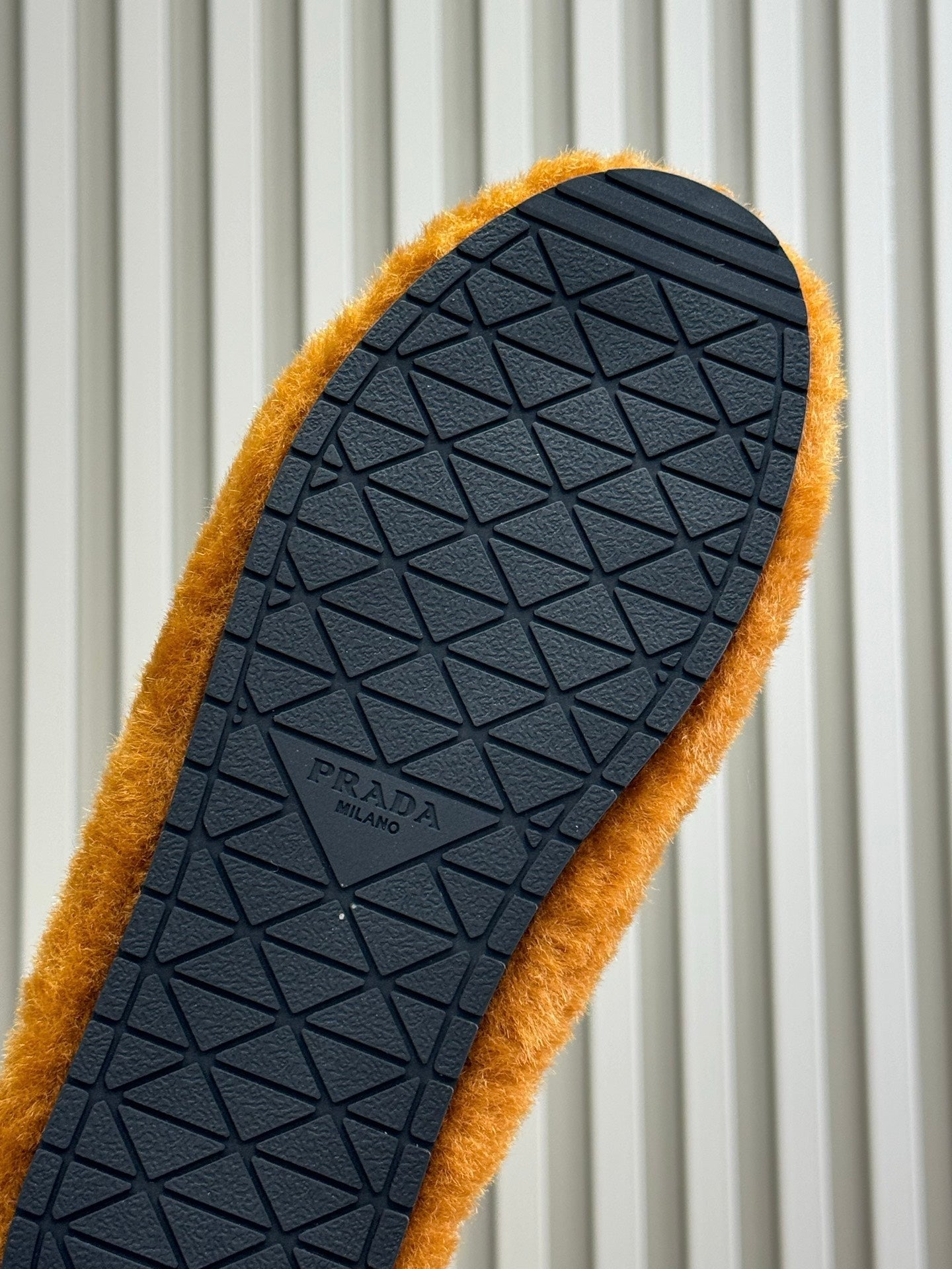 PRADA 25S CLOGS IN DARK ORANGE SHEARLING