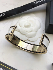 CHANEL 26S CHANEL LOGO ENAMEL CUFF BRACELET WITH BLACK TRIM IN GOLD METAL 630835